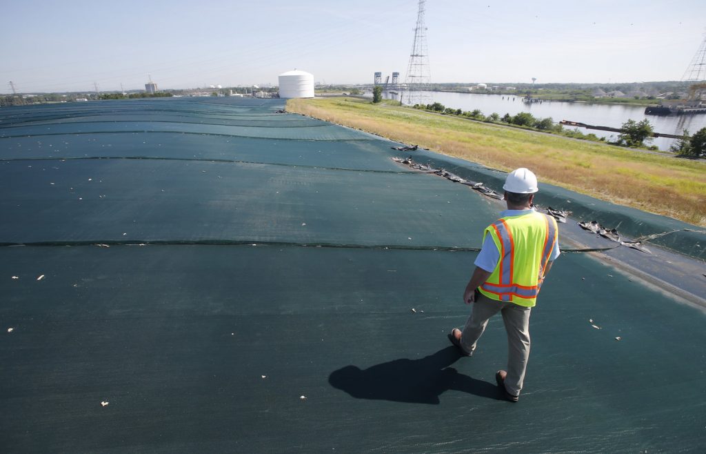 Utilities like Dominion Virginia argue water-proof caps ,like the one pictured here being used on one of the coal ash basins near the Elizabeth River, provide the same benefits as excavation. Courtesy:AP