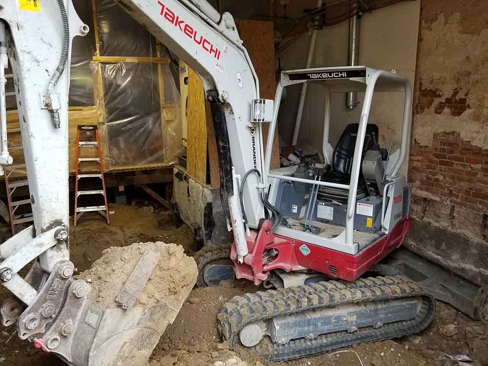 Soil excavator removing contaminated soil from environmental cleanup site.