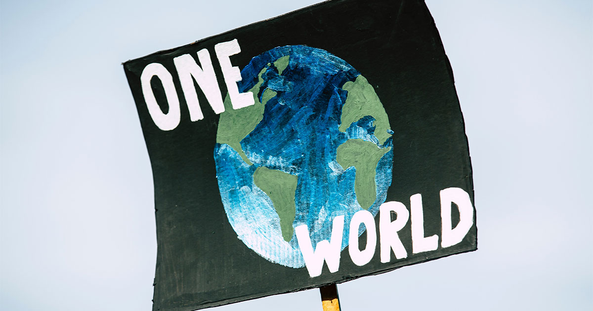 Picture of protest sign with the words one world on it