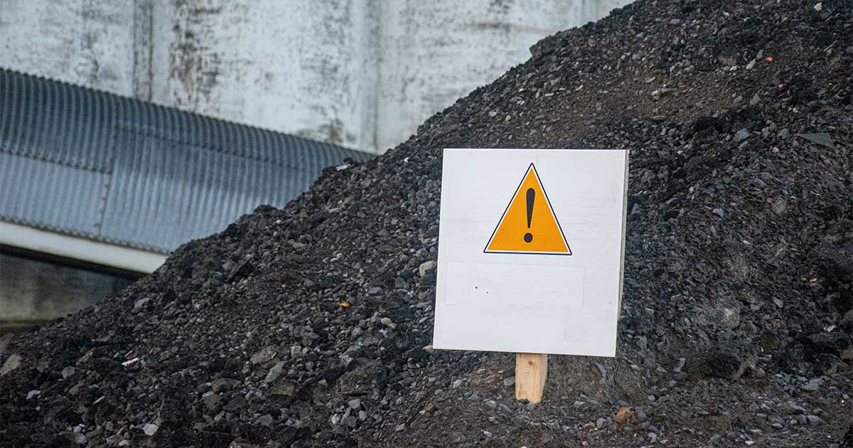 caution sign in pile of perc contaminated soil