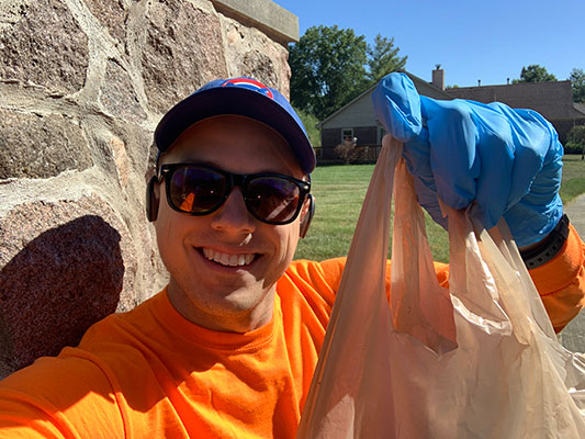 Alex Miller holding up trash bag