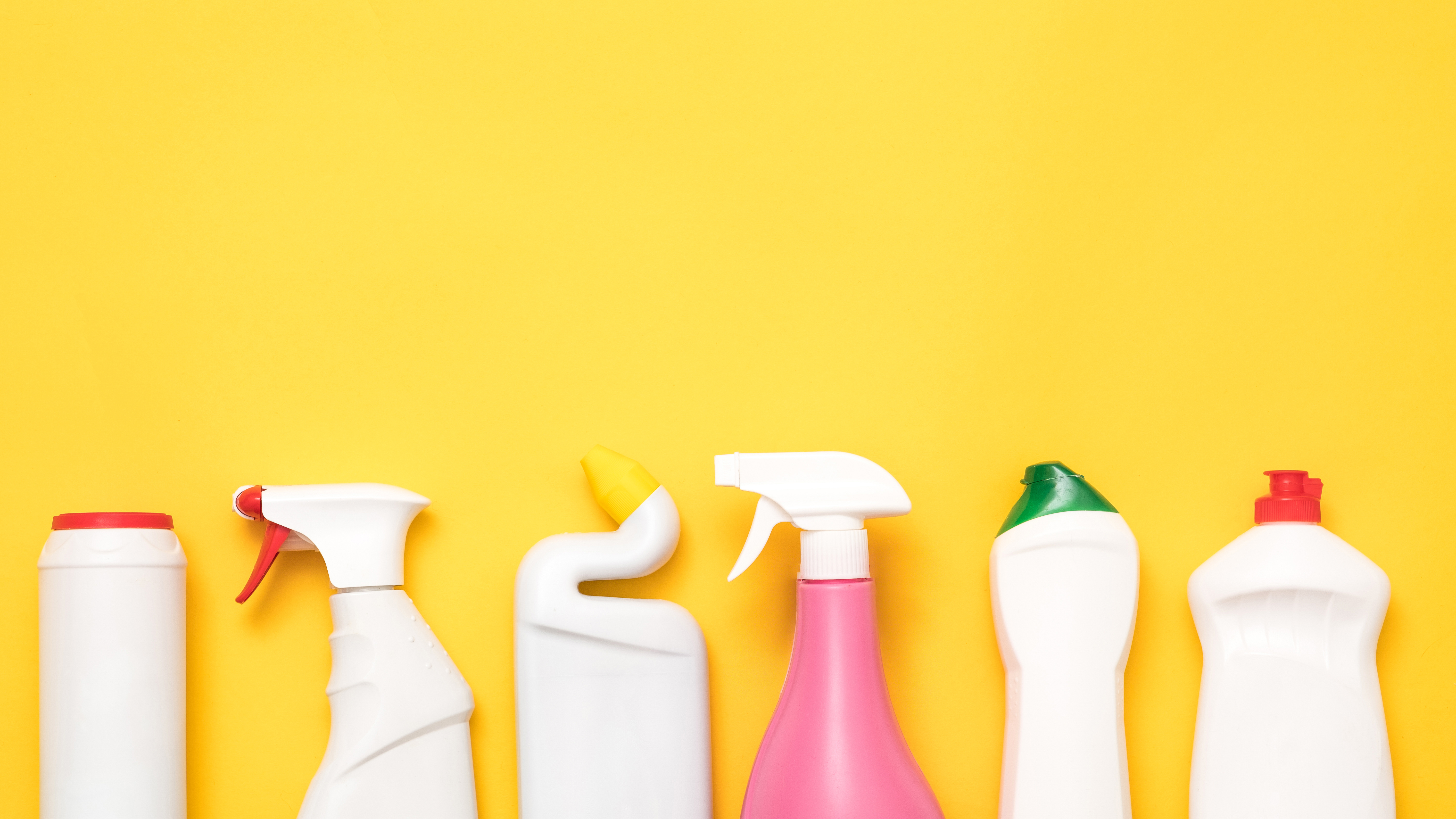 Cleaning products that contain PFAS in front of yellow background