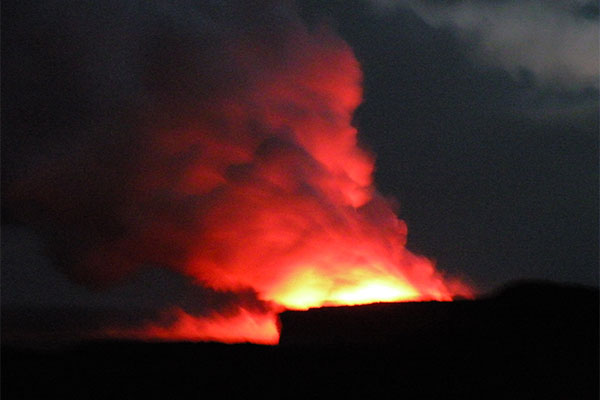 Picture of glowing orange and red cloud turning into steam at Hawaiʻi Volcanoes National Park