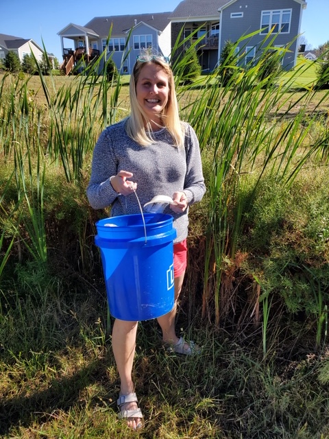 Morgan picking up trash in field of tall grass