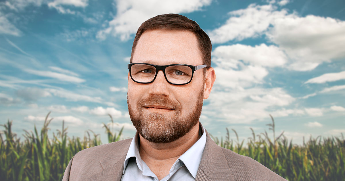 Headshot of Rob Hoverman in front of sunlit cornfield