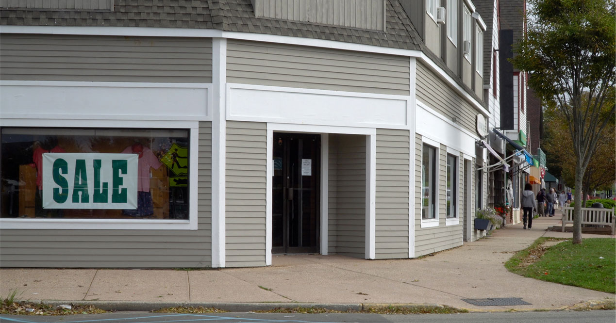 Drycleaner in a strip mall with a for sale sign 