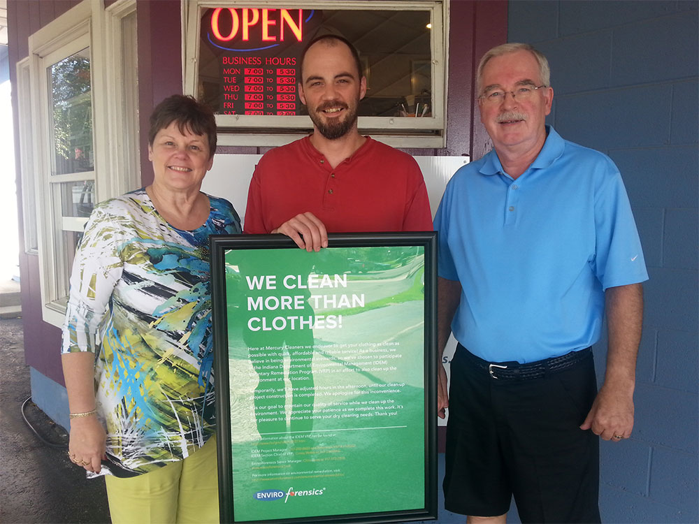 The Dygert Family, owners of Mercury Cleaners holding sign in front of business promoting their environmental remediation efforts