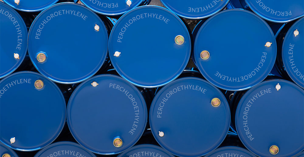 Blue drums filled with perc or perchloroethylene stacked on top of one another
