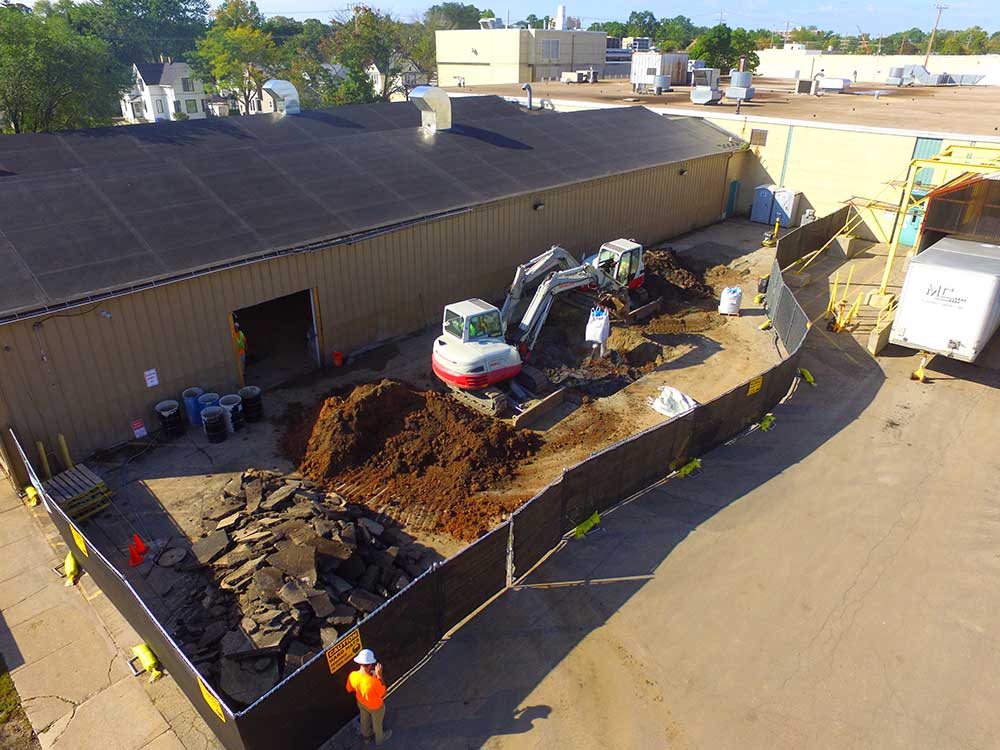 Aerial view of the remedial method of soil excavation outside of an industrial warehouse